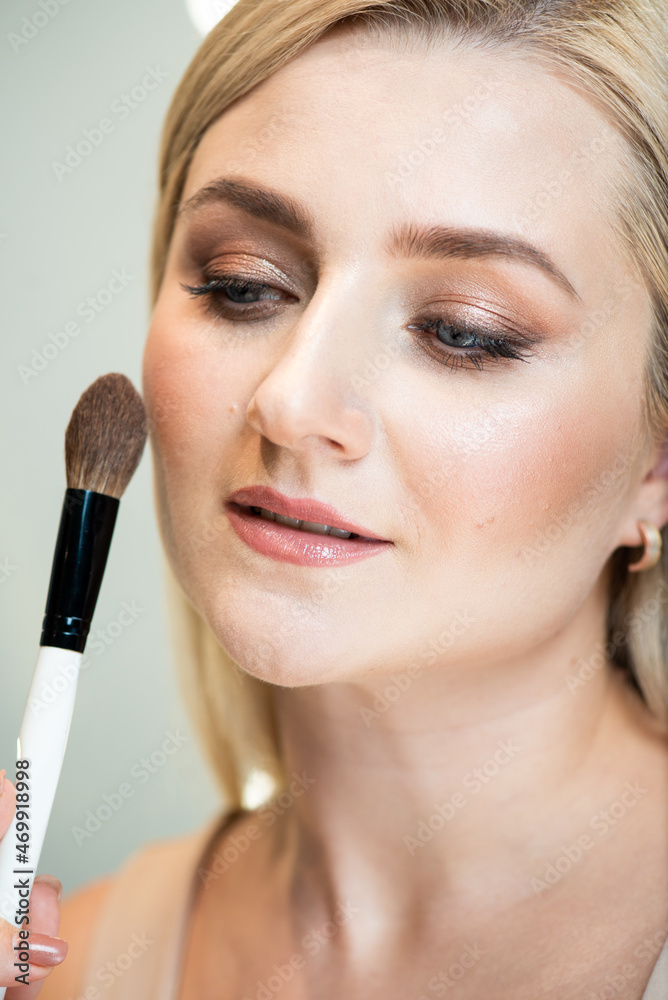Blonde woman doing self make up Blonde woman doing self make up