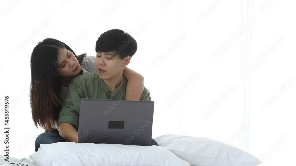 Happy Asian lesbian couple leisure activity concept, young female embracing elder talking looking laptop omline shopping on bed Happy Asian lesbian couple leisure activity concept, young female embracing elder talking looking laptop omline shopping on bed