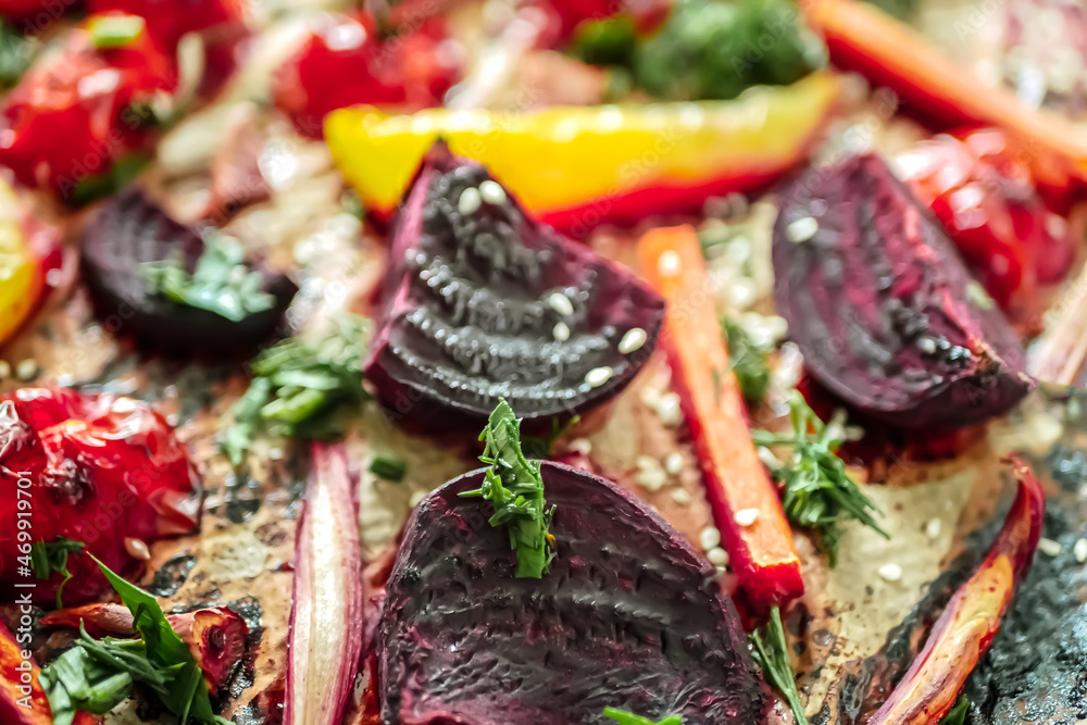 Fototapeta premium Roasted vegetables beets, tomatoes, peppers, carrots, close up. Vegan recipe baked vegetables background. Healthy food concept, Baked vegetables in the oven close-up