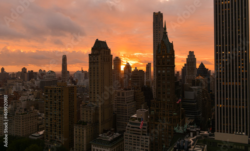 Sunrise in Manhattan, New York city. The sun is rising up between the skyscraper tall buildings creating an amazing vivid color sky. Landmarks of the United States of America.