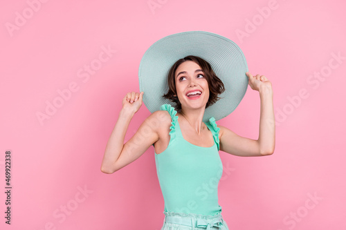 Portrait of attractive cheerful girl wearing sunhat dancing having fun isolated over pink pastel color background
