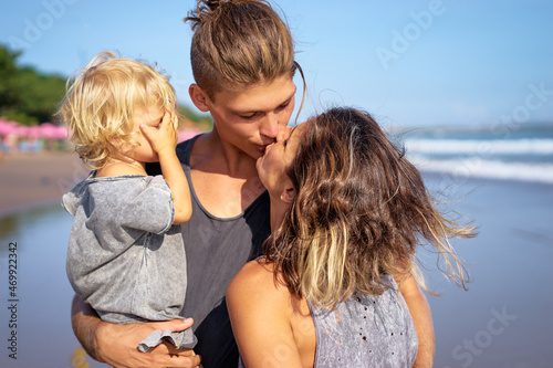 Family holiday near the sea. Father, mother and little daughter on beach. © luengo_ua