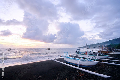 Beautiful sunrise. Ocean, beach and indonesian fishing boats. photo