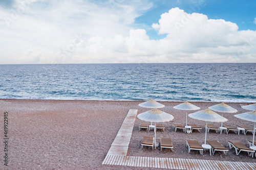 Seashore vacation. Mediterranean sea beach with sun loungers and umbrellas.