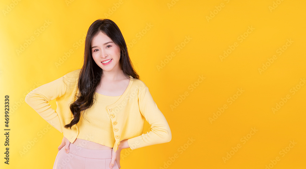 Confident charming Asian young woman wear hipster style standing over isolated yellow background. Cheerful student or businesswoman smart success while looking at camera. Confident charming Asian young woman wear hipster style standing over isolated yellow background. Cheerful student or businesswoman smart success while looking at camera.