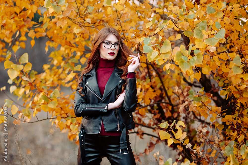 portrait of a beautiful young woman, wearing stylish glasses, looking at the camera. Happy, confident, smart young woman in autumn foliage portrait of a beautiful young woman, wearing stylish glasses, looking at the camera. Happy, confident, smart young woman in autumn foliage