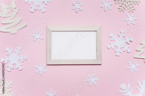 Christmas composition with white decorations on a pink background. Empty white frame with place for text. Christmas pattern. Flat lay, top view, copy space, mock up © etonastenka