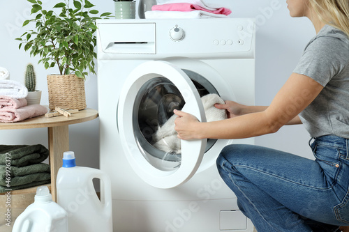 Concept of housework with washing machine and girl on white background photo