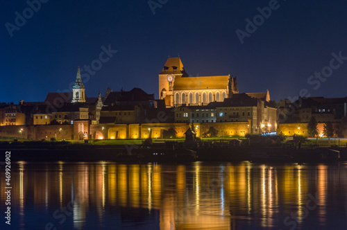 Old town of Torun with Church of St. John the Baptist and St. John the Evangelist. View on vistula river at night.