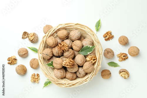 Walnuts in wicker bowl on white background photo