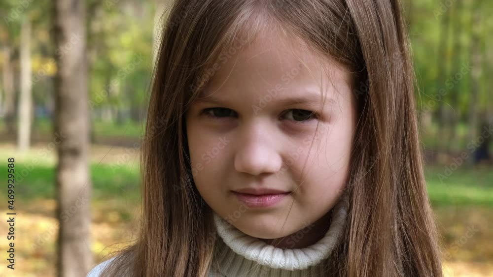 Portrait Thoughtful Little Girl Smiling Looking at Camera. Face Kid outdoors. Child in the Park on Sunny Day. Closeup Portrait Thoughtful Little Girl Smiling Looking at Camera. Face Kid outdoors. Child in the Park on Sunny Day. Closeup