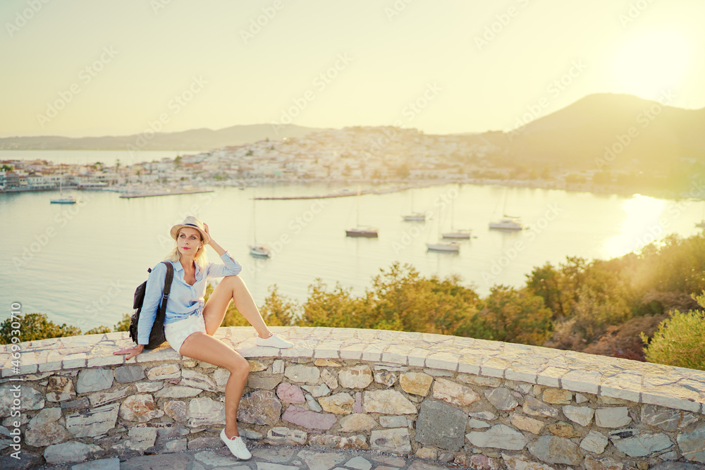 Enjoying vacation in Greece. Young traveling woman enjoying sunset on sea view point.