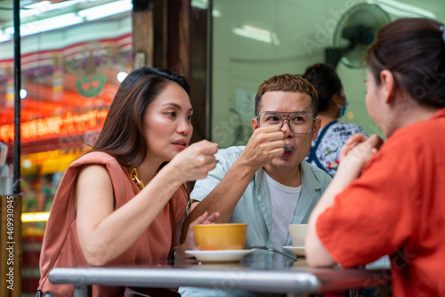 Group of Asian people friends tourist having dinner together at Chinatown street night market in Bangkok city  Thailand. Male and female friend enjoy outdoor lifestyle nightlife and eating street food