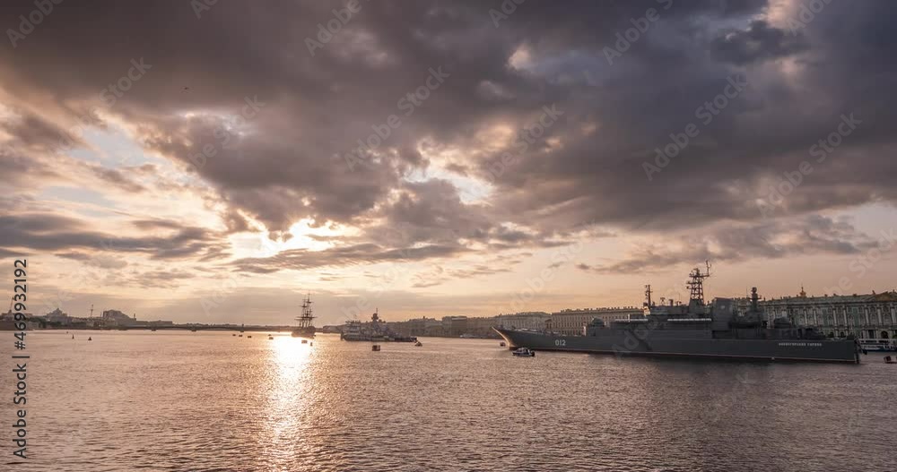 Ships on the Neva in St. Petersburg, before the Navy parade. A beautiful view of the dawn city with ships on their shores. The mesmerizing movement of clouds and sun will immerse you in the magical wo Ships on the Neva in St. Petersburg, before the Navy parade. A beautiful view of the dawn city with ships on their shores. The mesmerizing movement of clouds and sun will immerse you in the magical wo