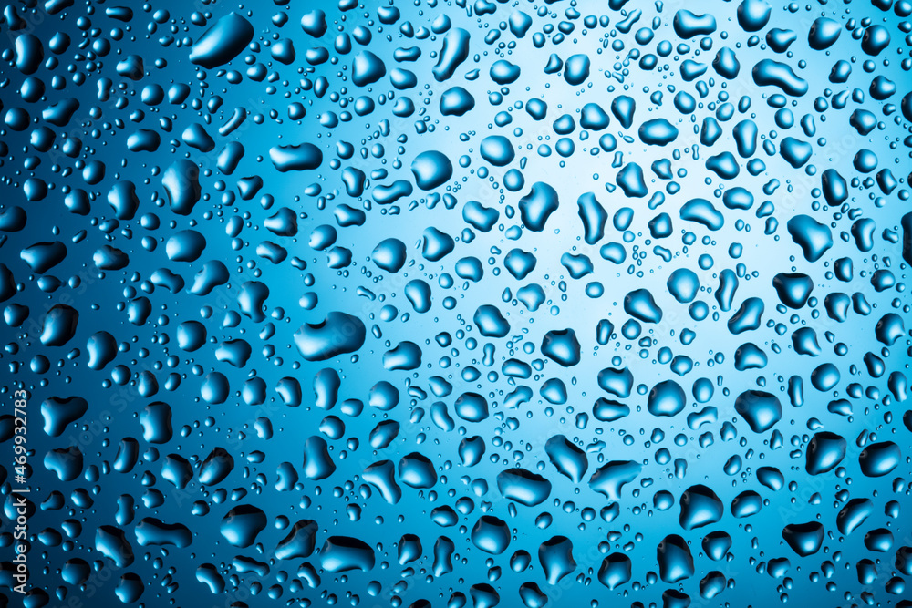 Water drops on glass on a blue background. Water drops on glass on a blue background.