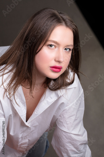 Portrait of a beautiful girl with red lips in a white shirt.