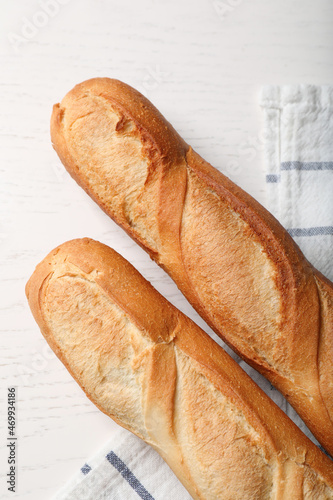 Tasty baguettes on white wooden table, flat lay