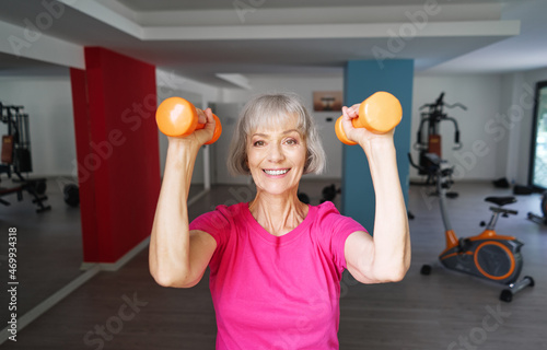 Healthy lifestyle and sport. Pretty senior woman exercising in gym.