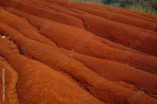 a red soil mound that makes a small river photo