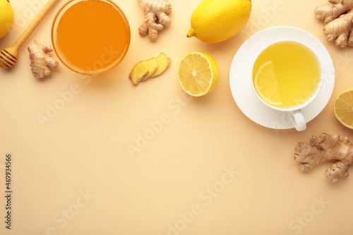 Ginger tea with lemon in a white cup on beige background.