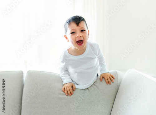 Photos Little crazy boy on living room look like hyperactive