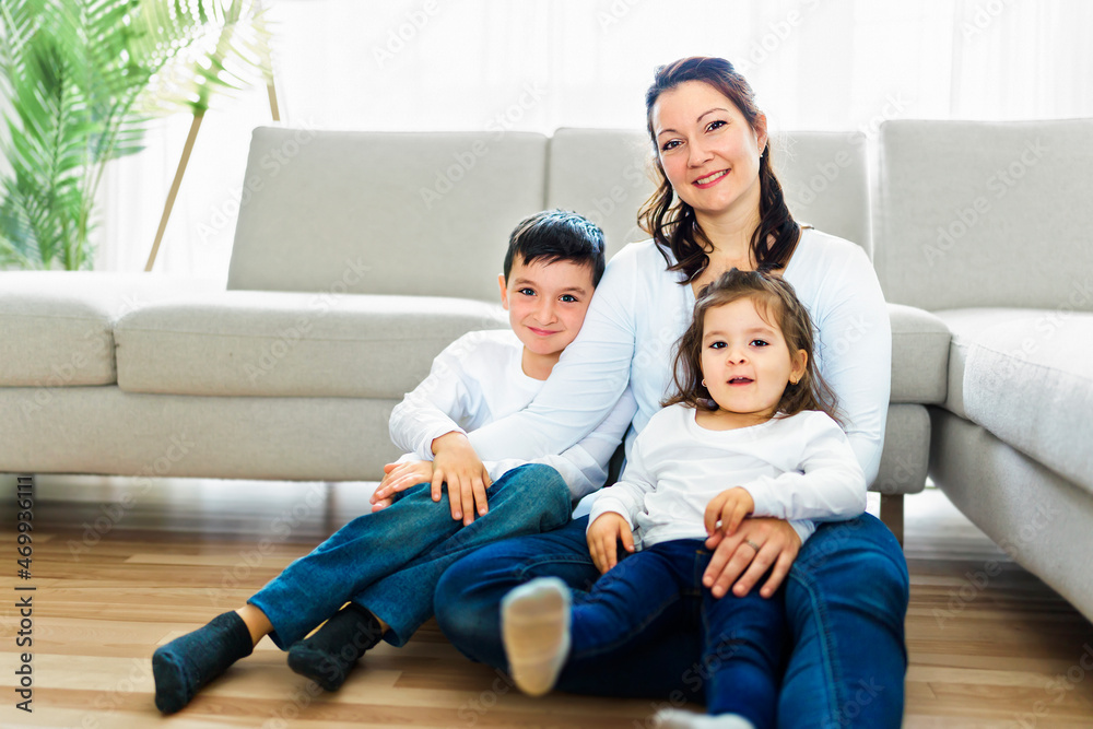 Loving mother with kids enjoying time together at home sofa