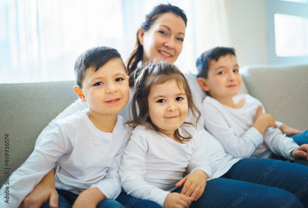 Loving mother with kids enjoying time together at home sofa