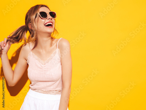 Young beautiful smiling female in trendy summer clothes. Sexy carefree woman posing near blue yellow in studio. Positive model having fun. Cheerful and happy. In sunglasses. Screaming and shouting © halayalex