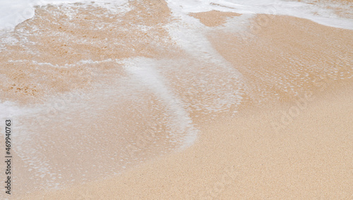 the texture of foamy waves of the sea against the sandy beach. the water flowing texture of the sea as the nature background texture collection.