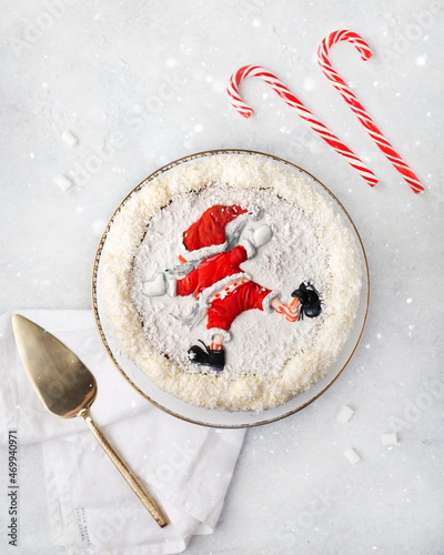 Christmas white cake decorated with the figure of Santa Claus on a white background with a Christmas decoration or winter holidays pastry food concept. Tpo view
