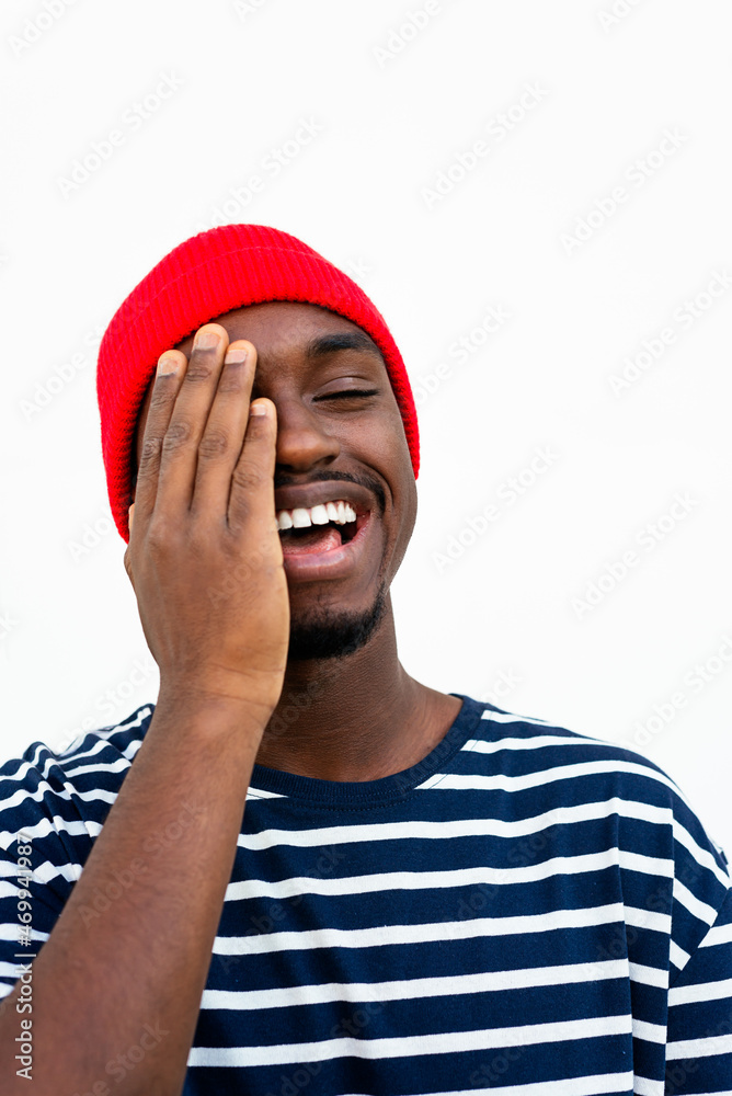 Smiling black man covering face with hand Smiling black man covering face with hand
