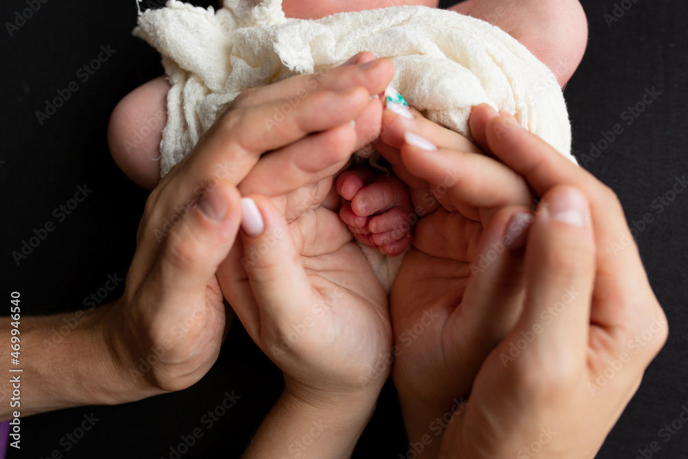 the legs of the child in the arms of the mother and the father the legs of a newborn baby the legs of the child in the arms of the mother and the father the legs of a newborn baby