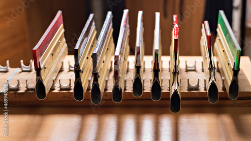 squeegees on wooden desk front view. serigraphy production. printing images on t-shirts by silk screen method in a design studio