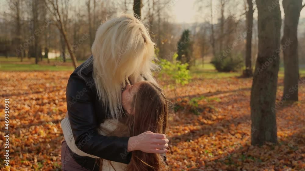 Mother and daughter having fun in autumn woods. Two female caucasian persons hug smile and laughing at park outdoors. Girl and woman different age spending time together outside. Happy childhood Mother and daughter having fun in autumn woods. Two female caucasian persons hug smile and laughing at park outdoors. Girl and woman different age spending time together outside. Happy childhood