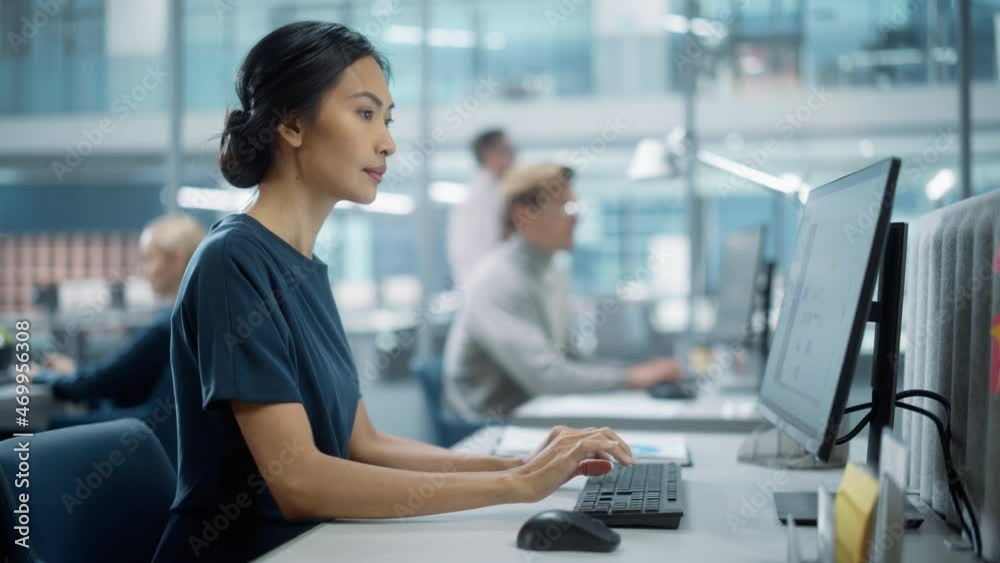 In Big Corporate Office: Portrait of Confident Beautiful Asian Manager Using Computer, Businesspeople and Experts Working Around Her, Analysing Statistics, Commerce Data, Marketing Plans.