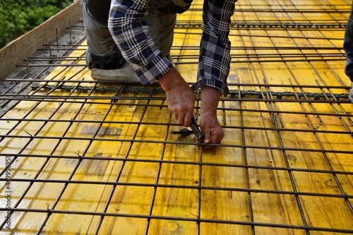 The mason connects with pliers by hand wires to the formwork walls for concreting