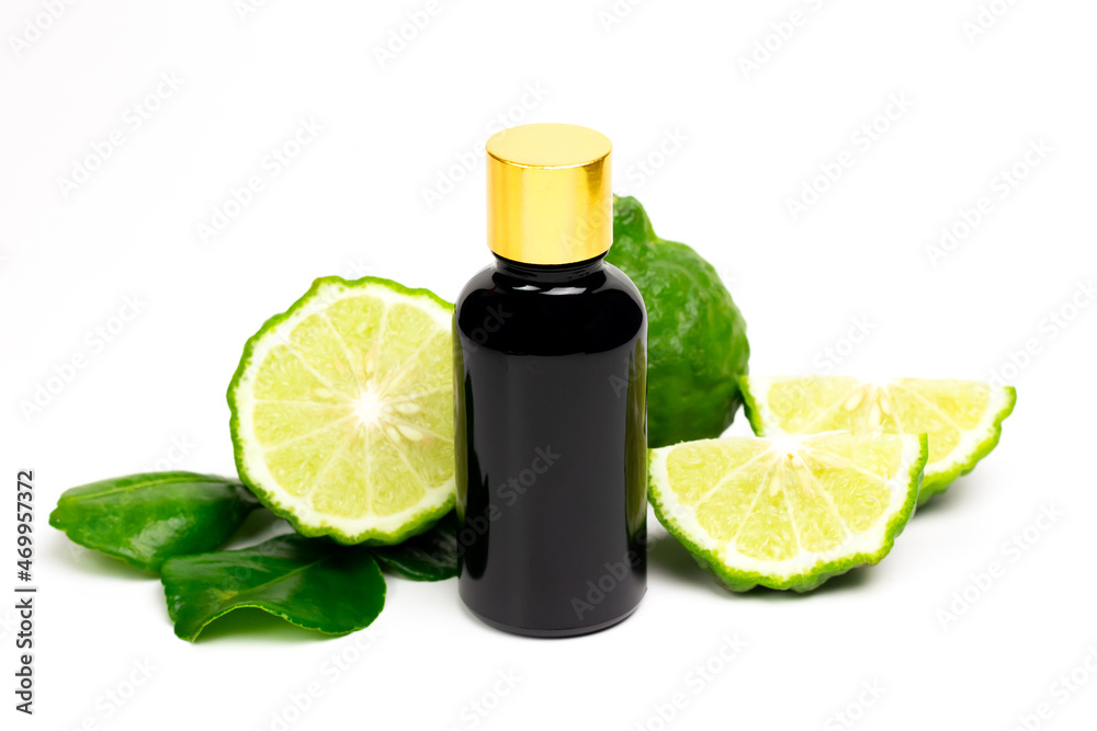 Bergamot oil in bottle and fresh bergamot fruit with green leaf isolated on white background.