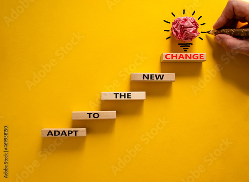 Adapt to the new change symbol. Wooden blocks with words Adapt to the new change on beautiful yellow background, copy space. Businessman hand, light bulb icon. Business, adapt to change concept. photo