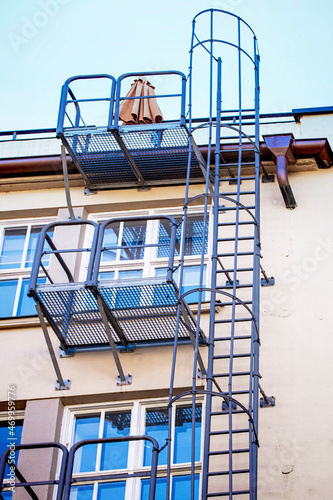 Utility ladder and fire escape stairs outside a modern apartment building photo