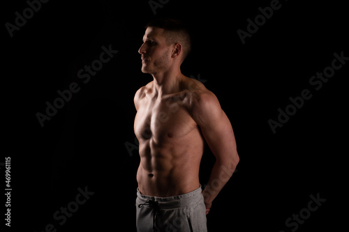 Man Showing ABS. Muscle man Posing. Strong Body Concept. Topless Sport man Bodybuilder. Six Pack Spotsman. Hands Behind Back © Alex