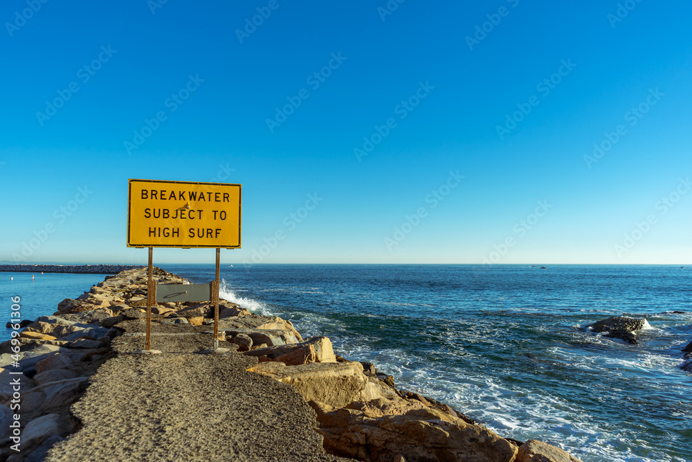 Breakwater Subject to High Surf sign in Dana Point, California - obrazy, fototapety, plakaty 
