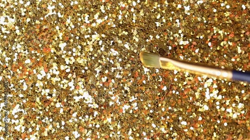 macro fur brush moves slowly to bitcoin real model covered with gold dust and cleans logo on top