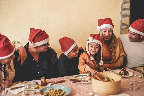 Happy latin family celebrating christmas together while enjoy dinner on restaurante terrace