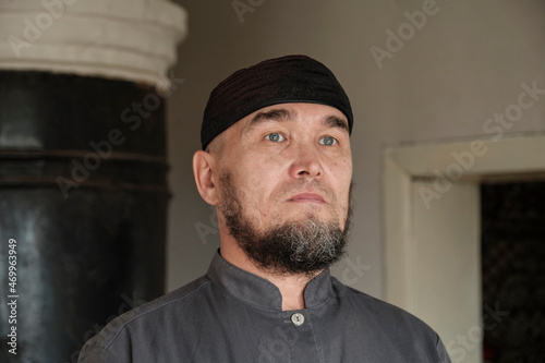 Close up portrait of serious senior asian muslim man wearing skullcap.