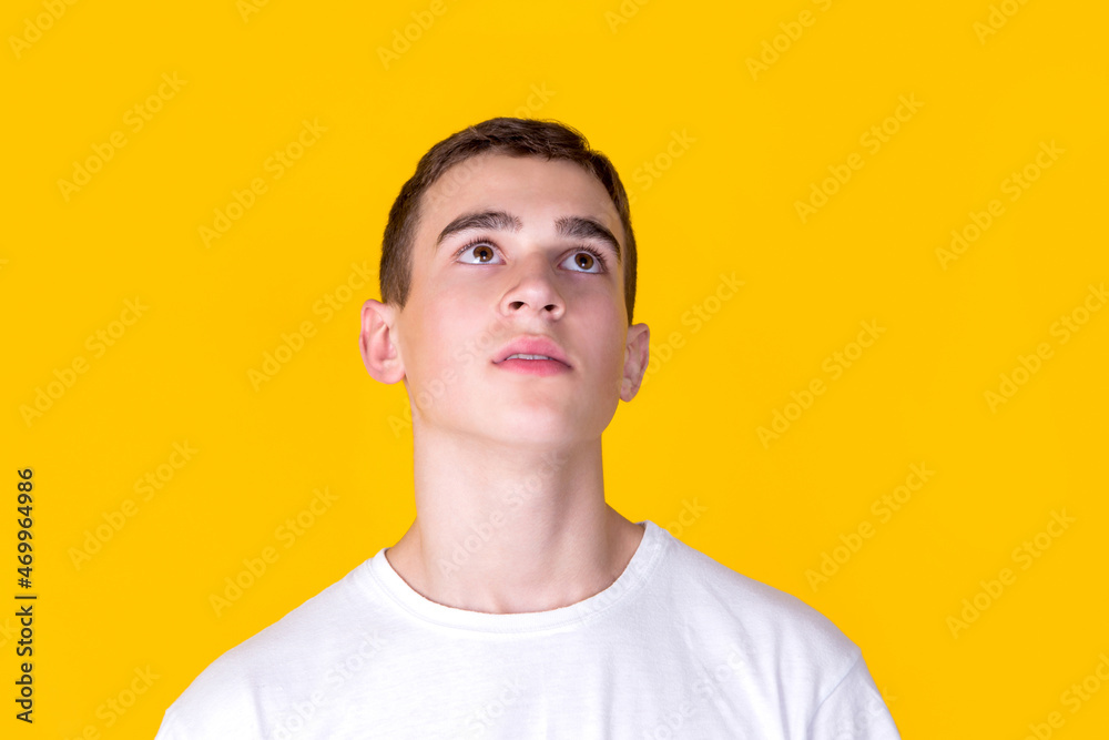 A handsome guy in a white t-shirt  on a yellow background