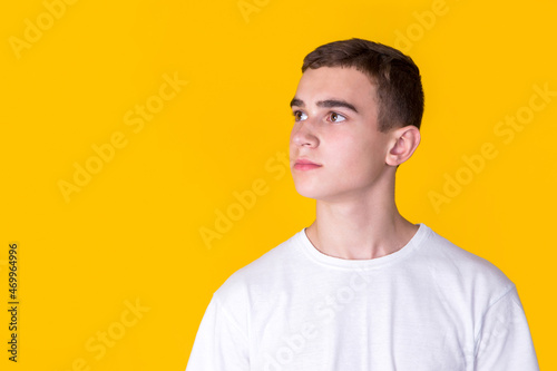 A handsome guy in a white t-shirt on a yellow background