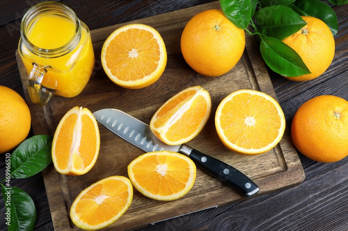 Fresh orange juice in a glass on a wooden background. Fresh Orange fruits with green leaves. Healthy vegan food. Vitamins food.Ripe oranges.Flat lay.