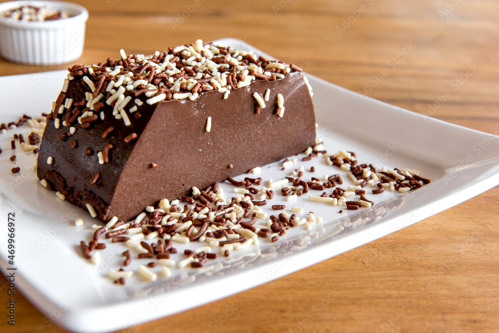 Piece of Chocolate pudding with sprinkles, delicious chocolate dessert on wooden table. Piece of Chocolate pudding with sprinkles, delicious chocolate dessert on wooden table.