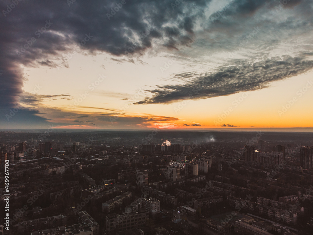 Aerial sunset evening view on residential Kharkiv city Pavlove Pole district. Multistory buildings district with scenic bright orange cloudy sky on horizon