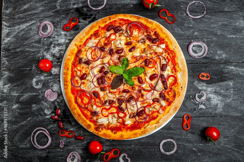 Pizza Quatro stagione with tomato sauce, salami, mushrooms, mozzarella, bacon, olives.